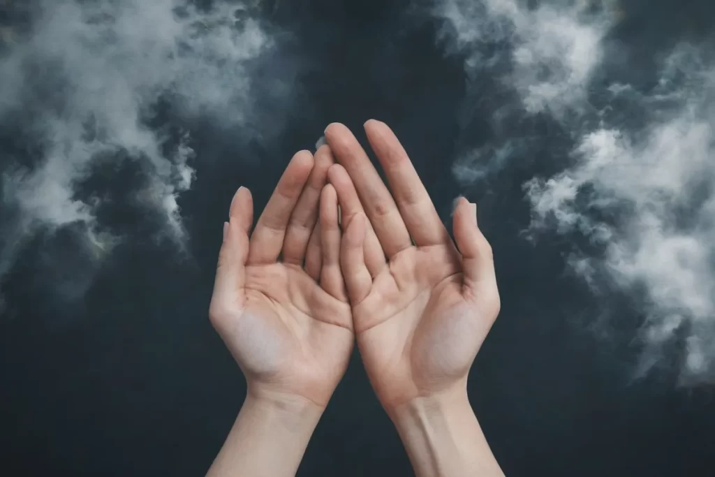 Una mano en mano y rostro preocupado mirando al cielo