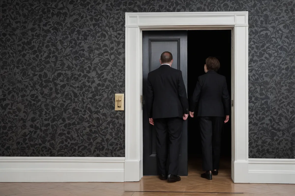 La pared de papeles muestra a personas frente a la puerta de la funeraria